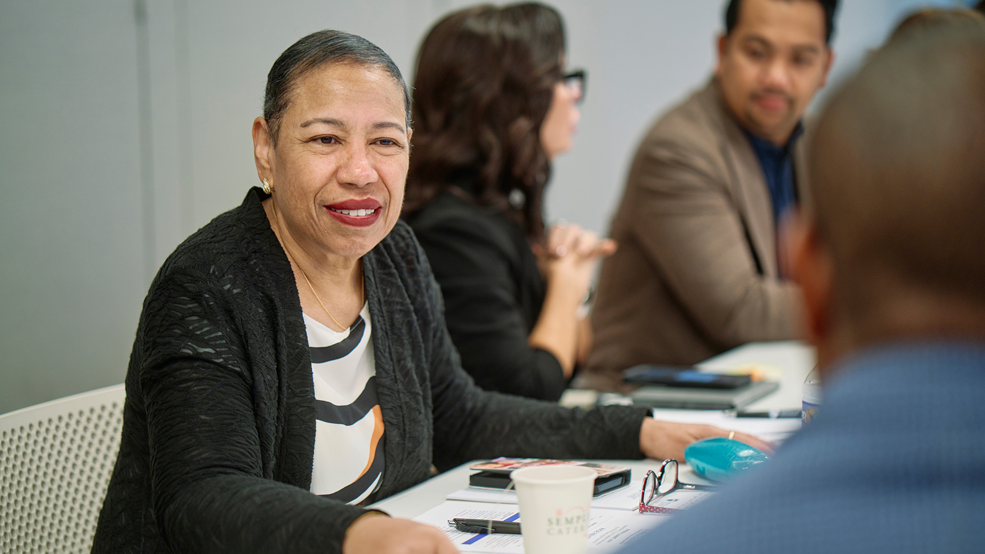 Angie Ribuffo sitting at a table with conference attendees