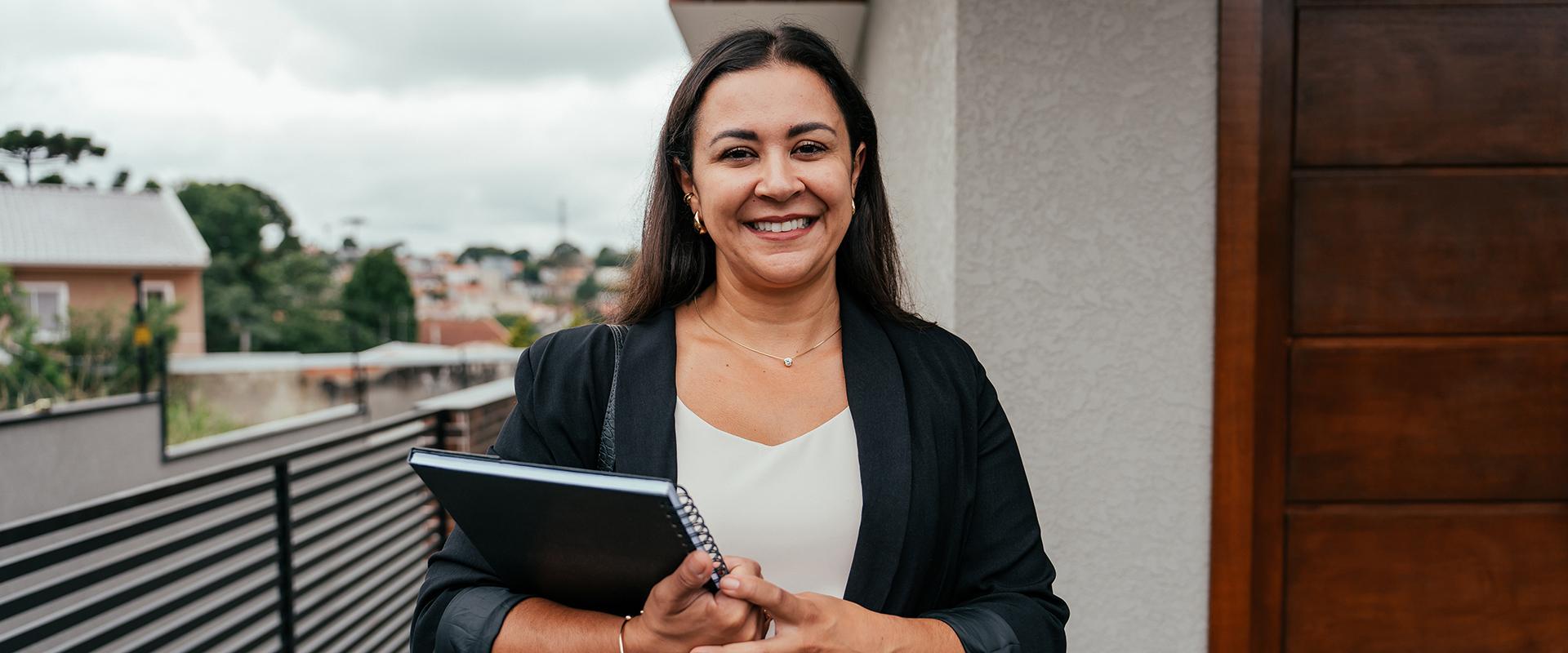 Latina woman smiling with notebook in her hand