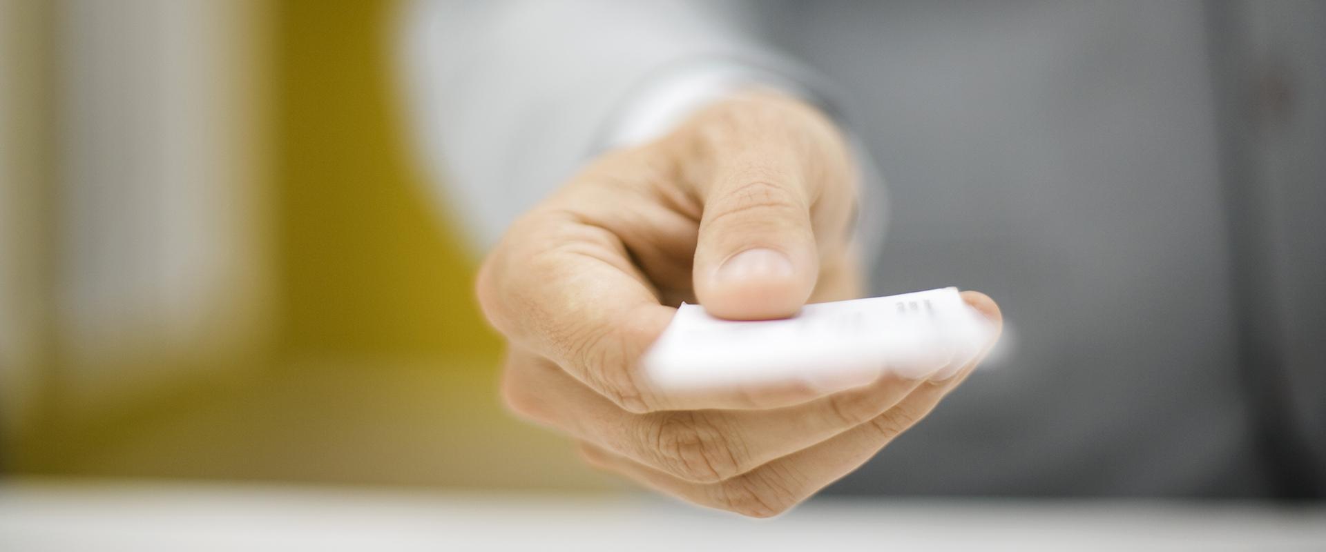 Hand stretched out handing in a card