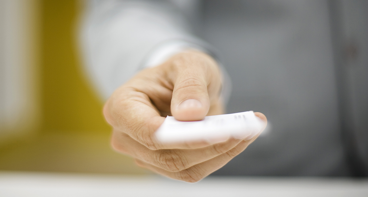 Hand stretched out handing in a card