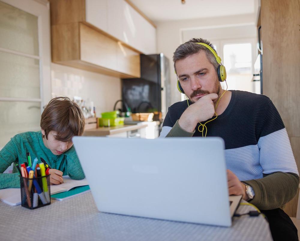 The College Alumni reviewing online resources in his kitchen