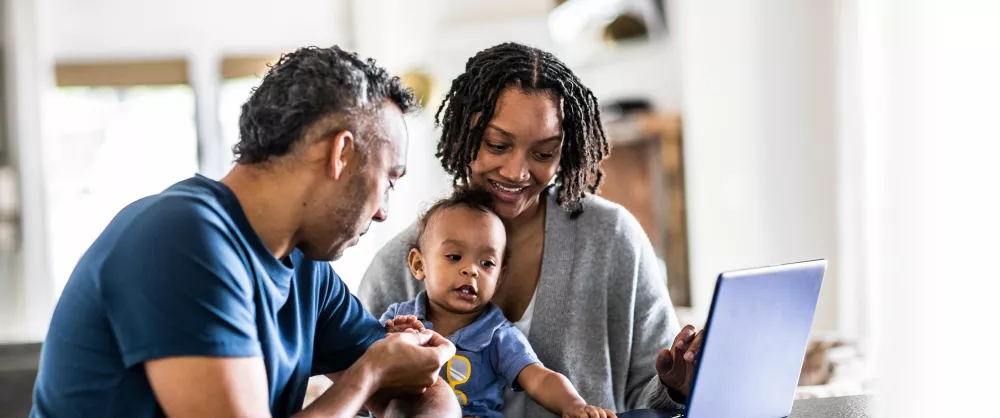 Young family using laptop at home