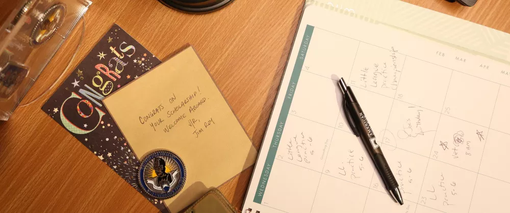 Handwritten congratulations card and planner on desk