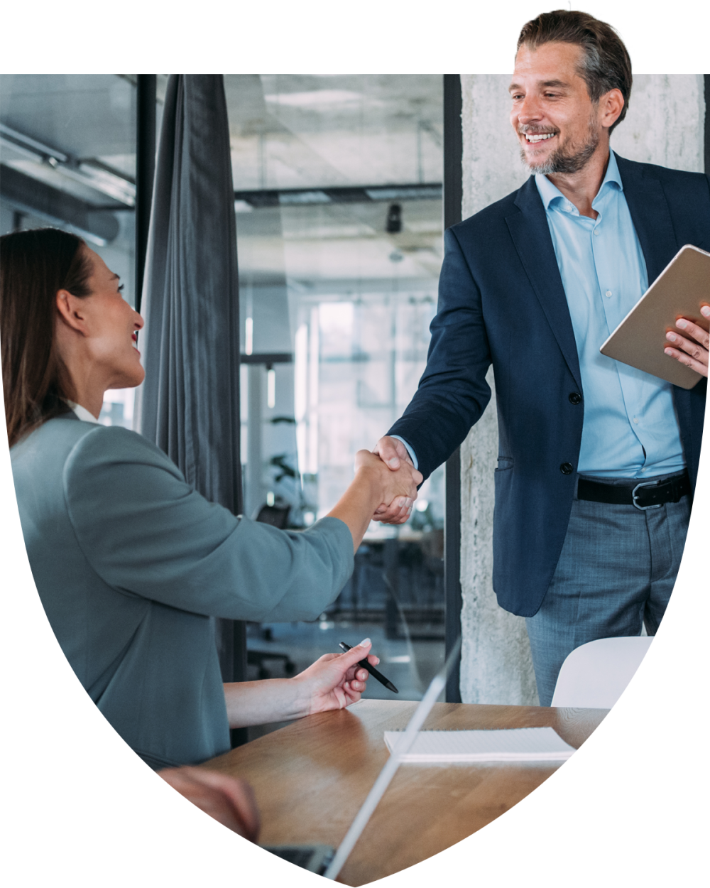 Professional man and woman greeting each other with handshake in the office