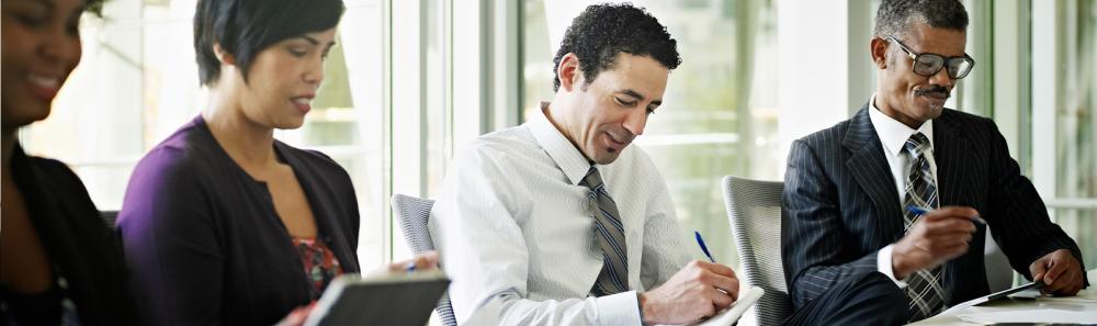 Group of financial professionals in the conference room taking notes