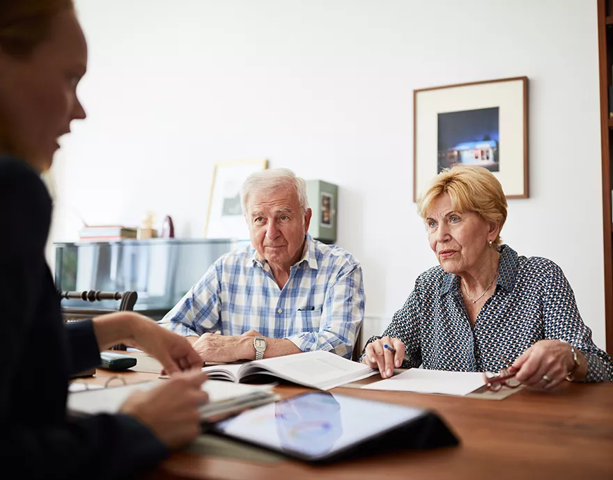 Image of a man talking to a couple across a table