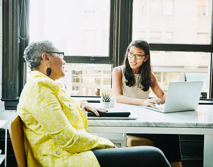 Two women speaking at a table