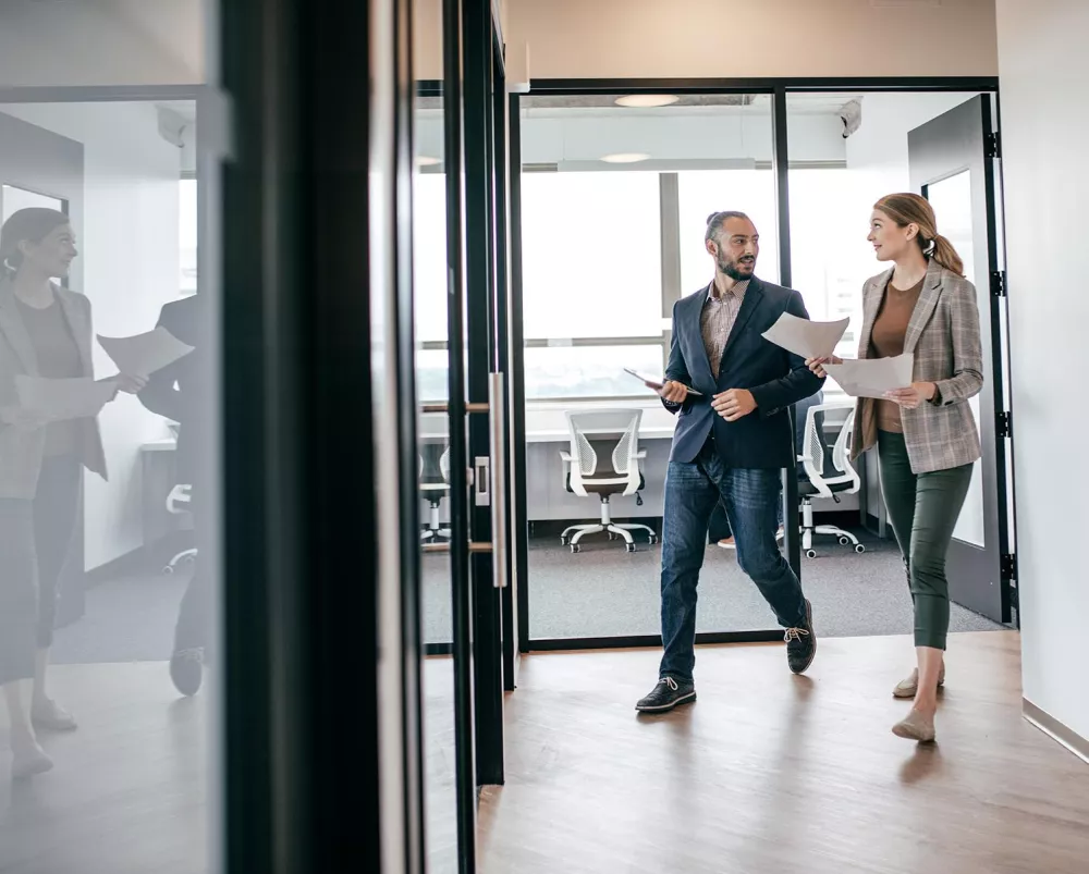 Two financial professional colleagues walking together in the office 