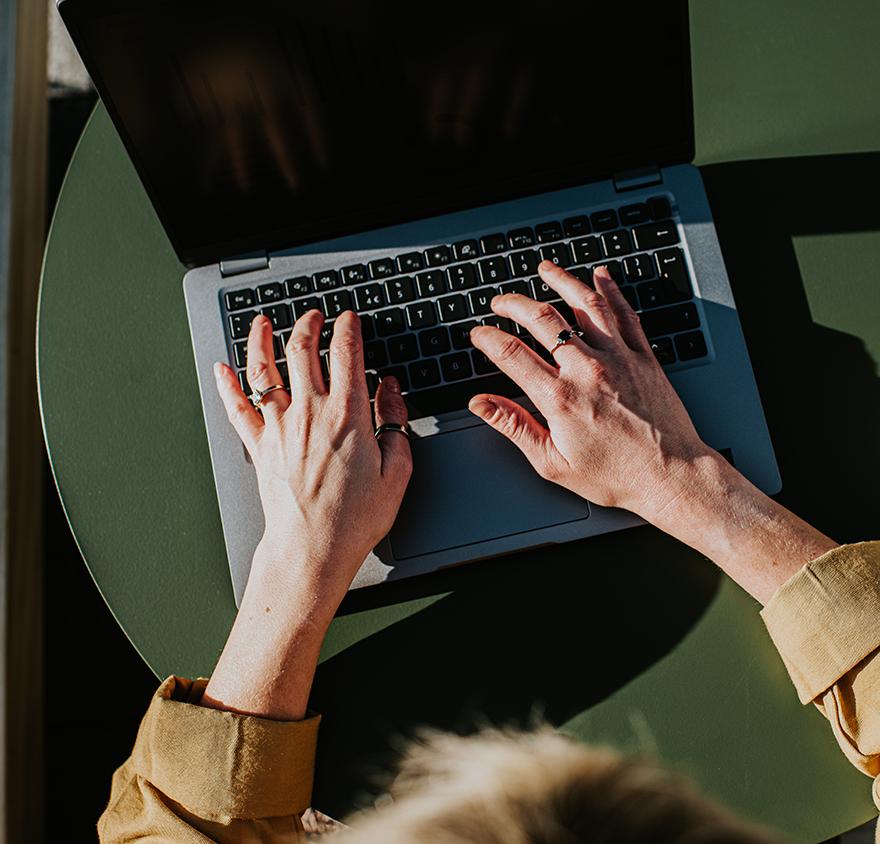 A close up of hands on a laptop keyboard