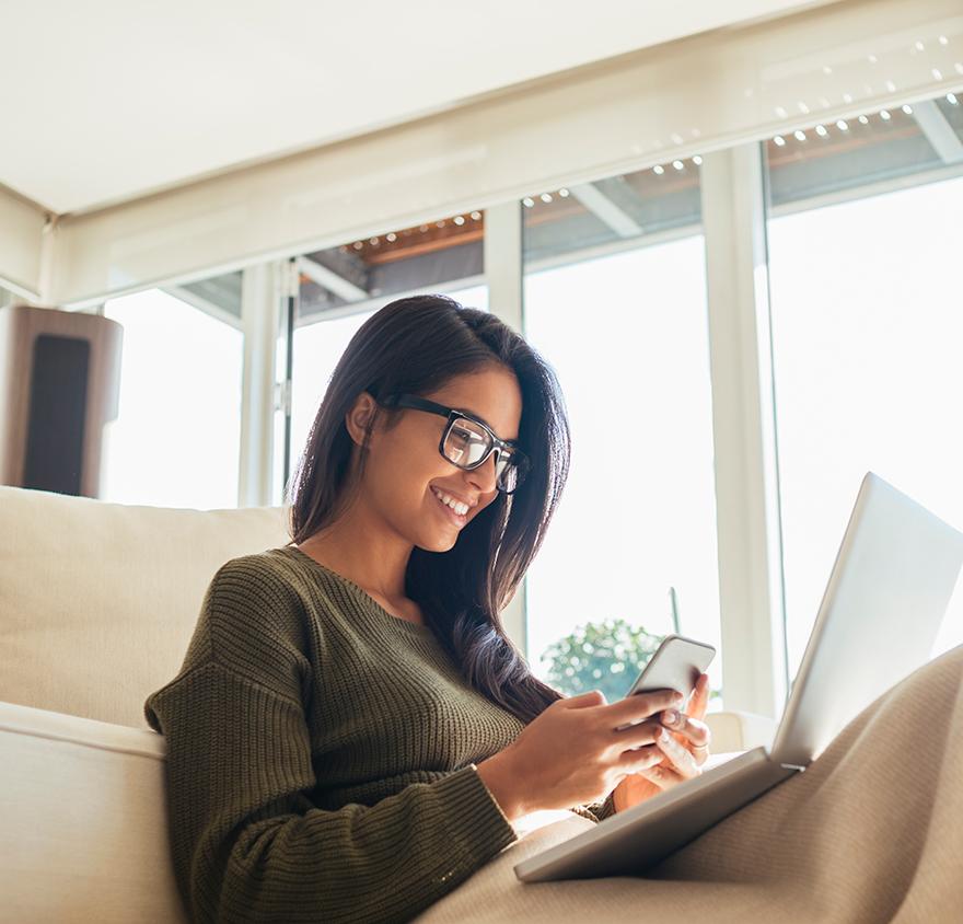 A woman sitting on a couch with a laptop