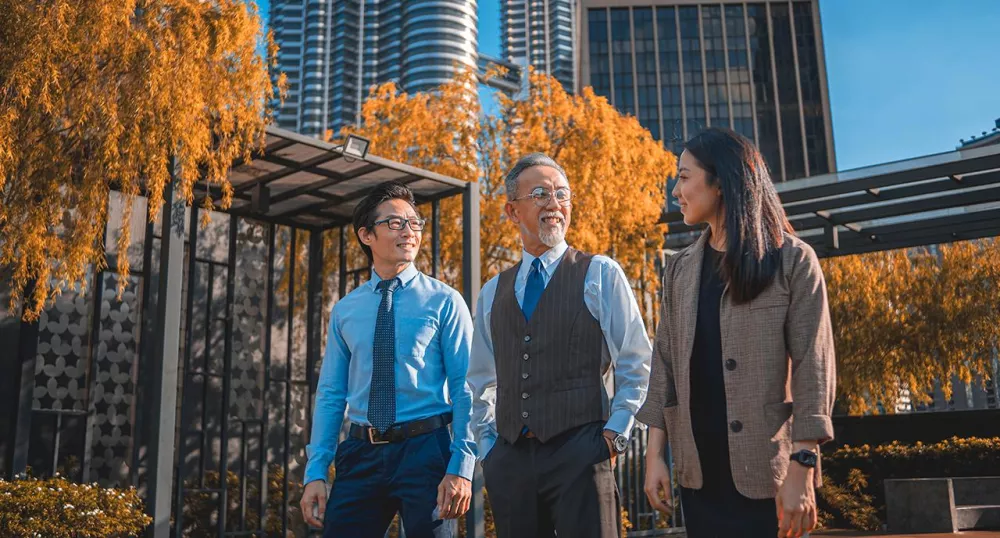 Three financial advisors walking together in the park