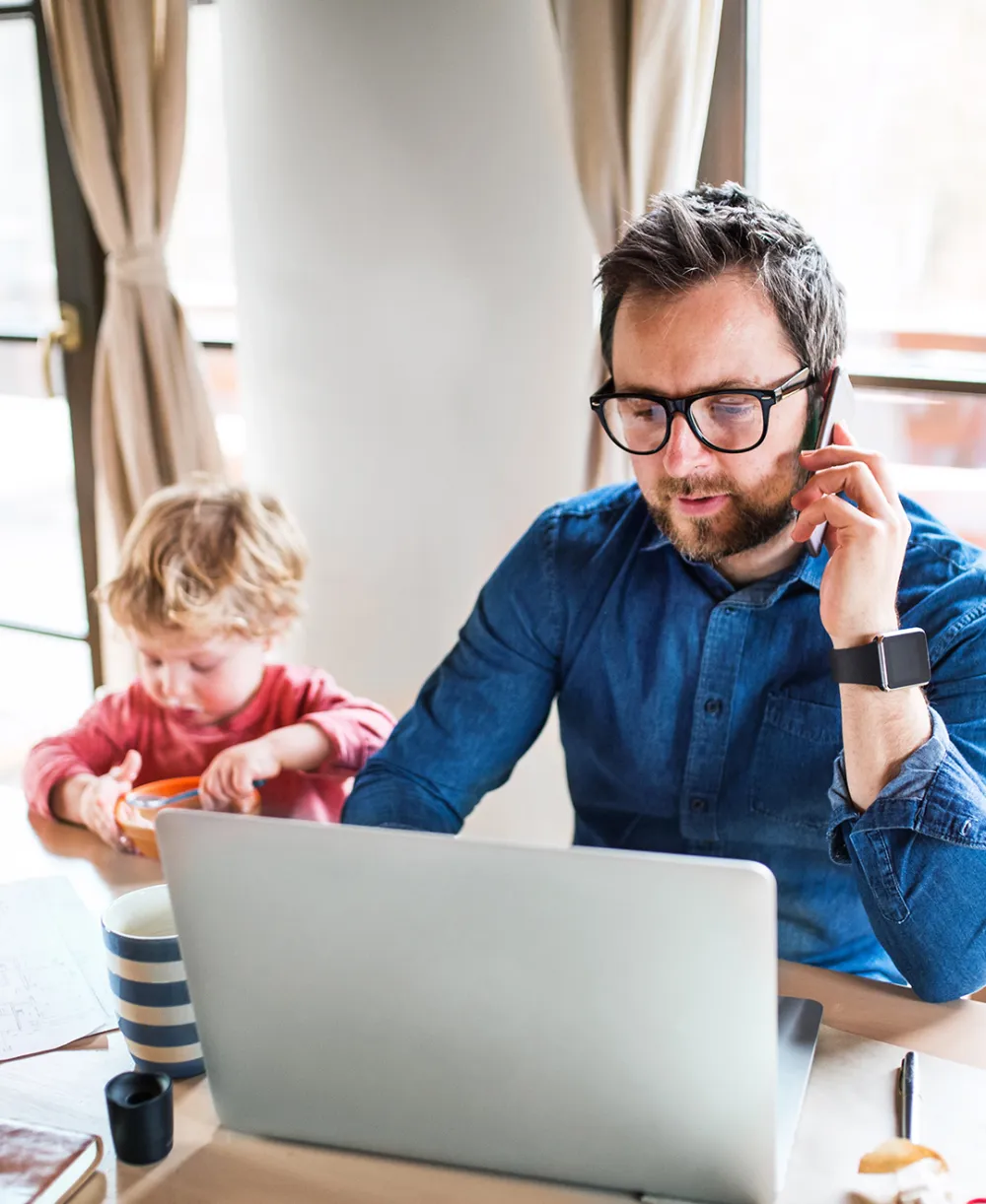 Dad working from home while taking care of his child