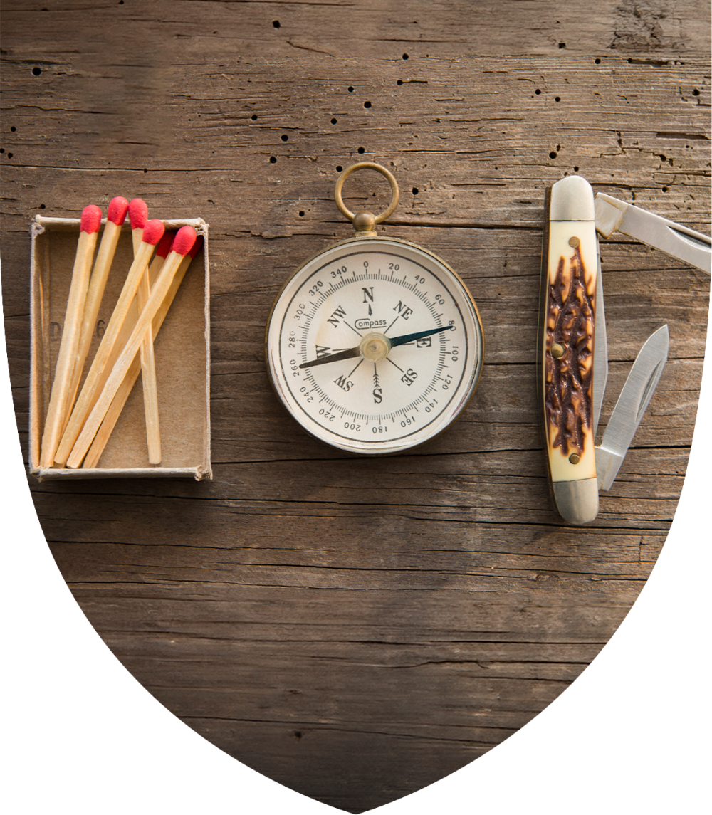 Matches, compass, and pocket knife on a table