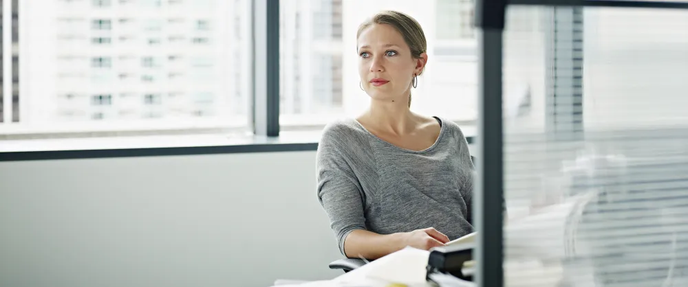 Middle aged woman smiling while sitting at her desk