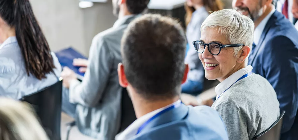 Two advisors sitting together in a crowd