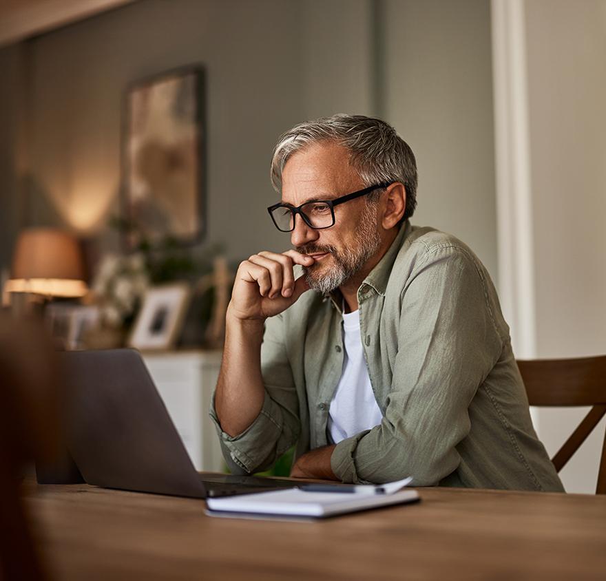 Middle aged man browsing Knowledge Hub + on his laptop