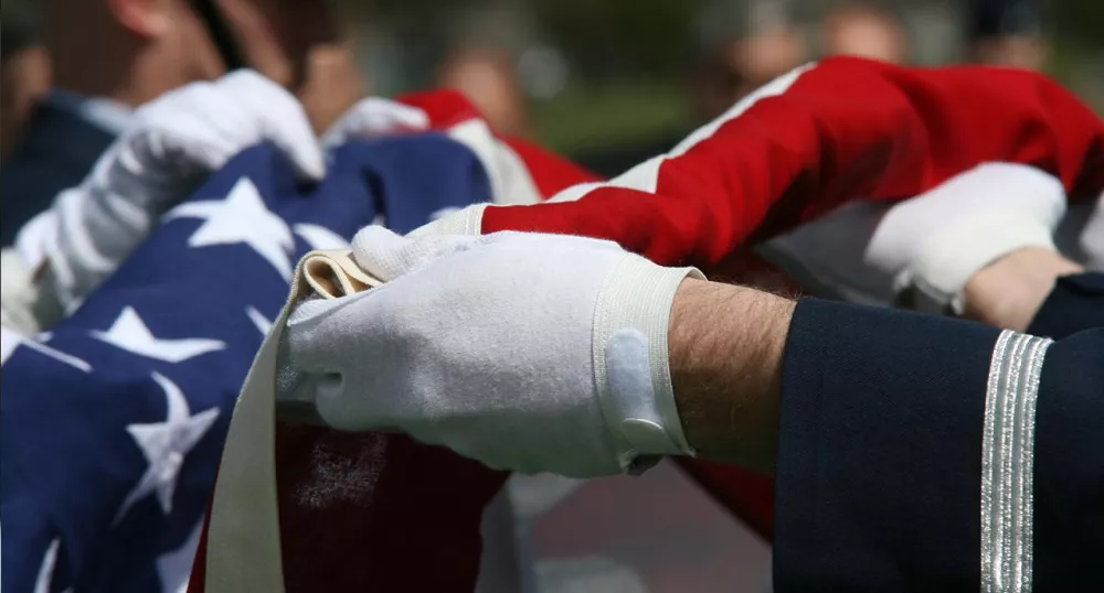 Military servicemen folding the American flag