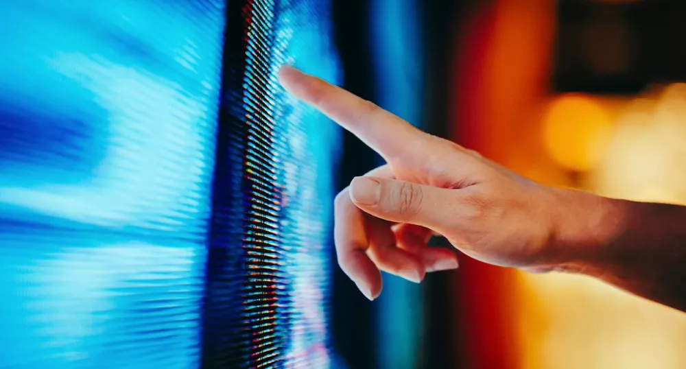 Outstretched hand pointing at lines of code on a screen