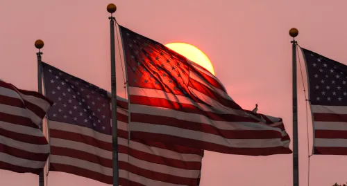 Four American Flags waving in the sunset