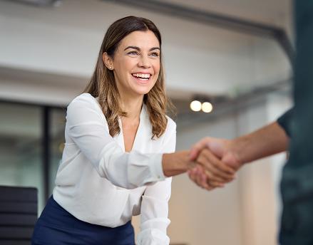 Female and male financial professionals shaking hands